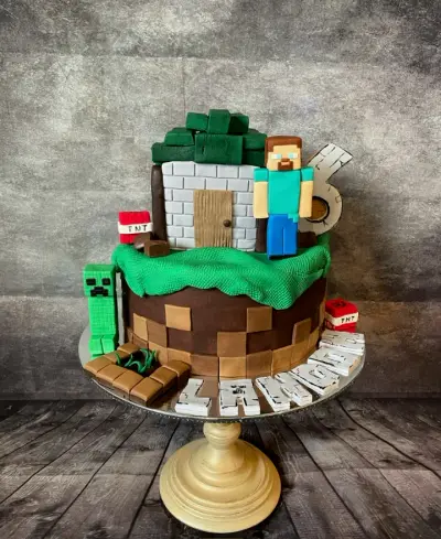 Two-tier cake styled as a Minecraft fort with a Steve figure, a Creeper, TNT blocks, a grass topper, and a number 6.